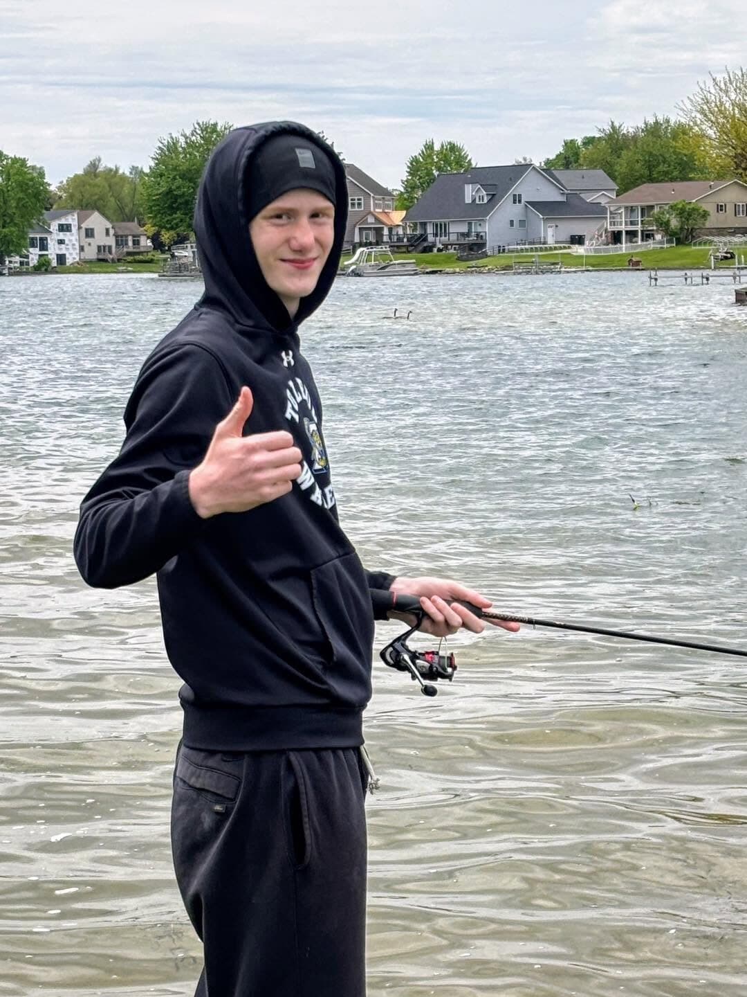 A student giving a thumbs up while fishing
