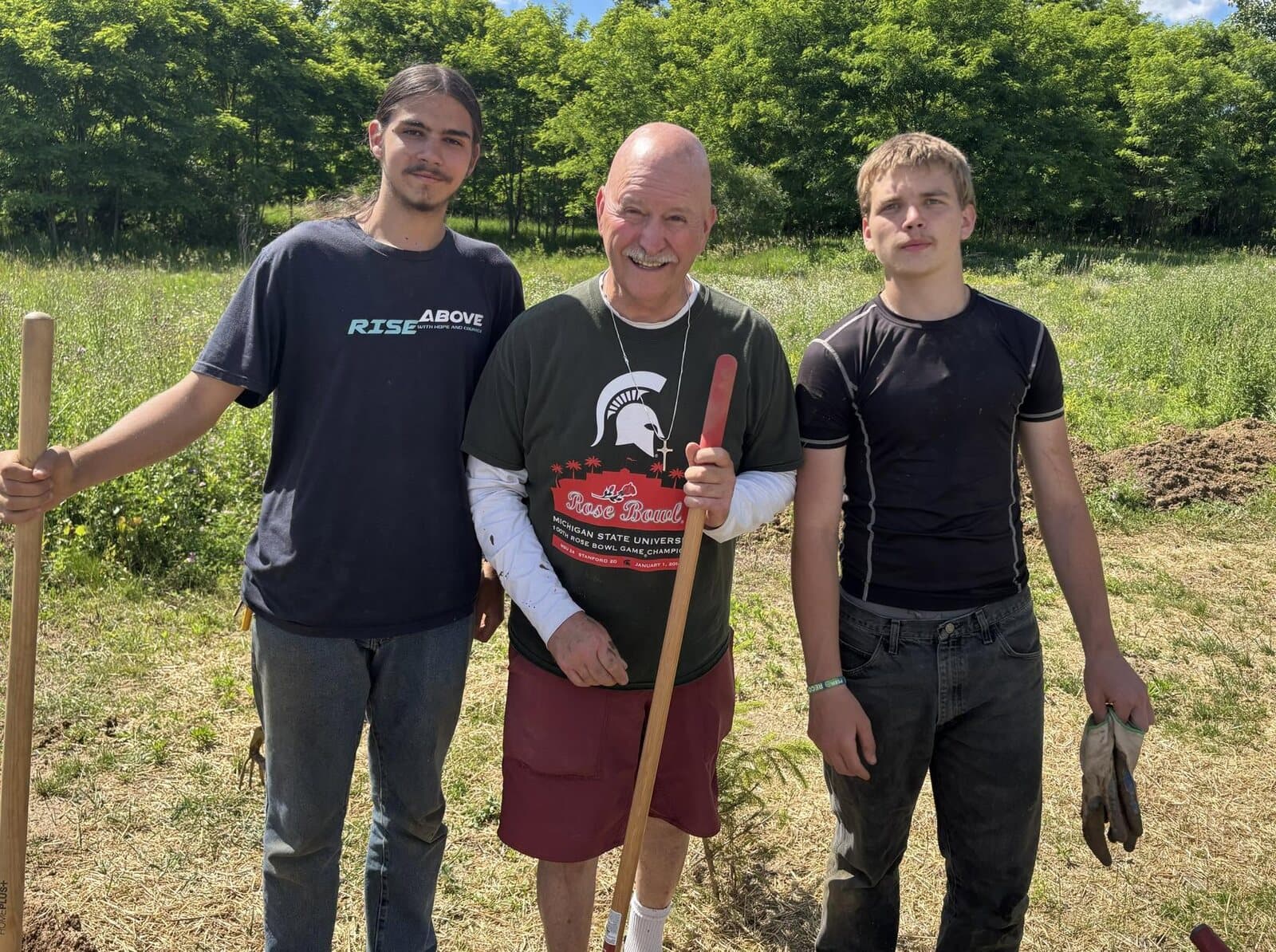Two Rise Above students and a mentor taking a break from a garden project